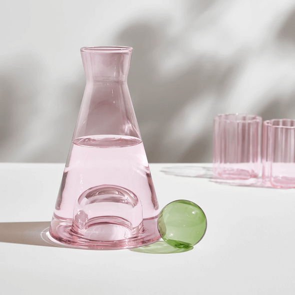 Pink wave glasses in the back ground of the pink and green carafe